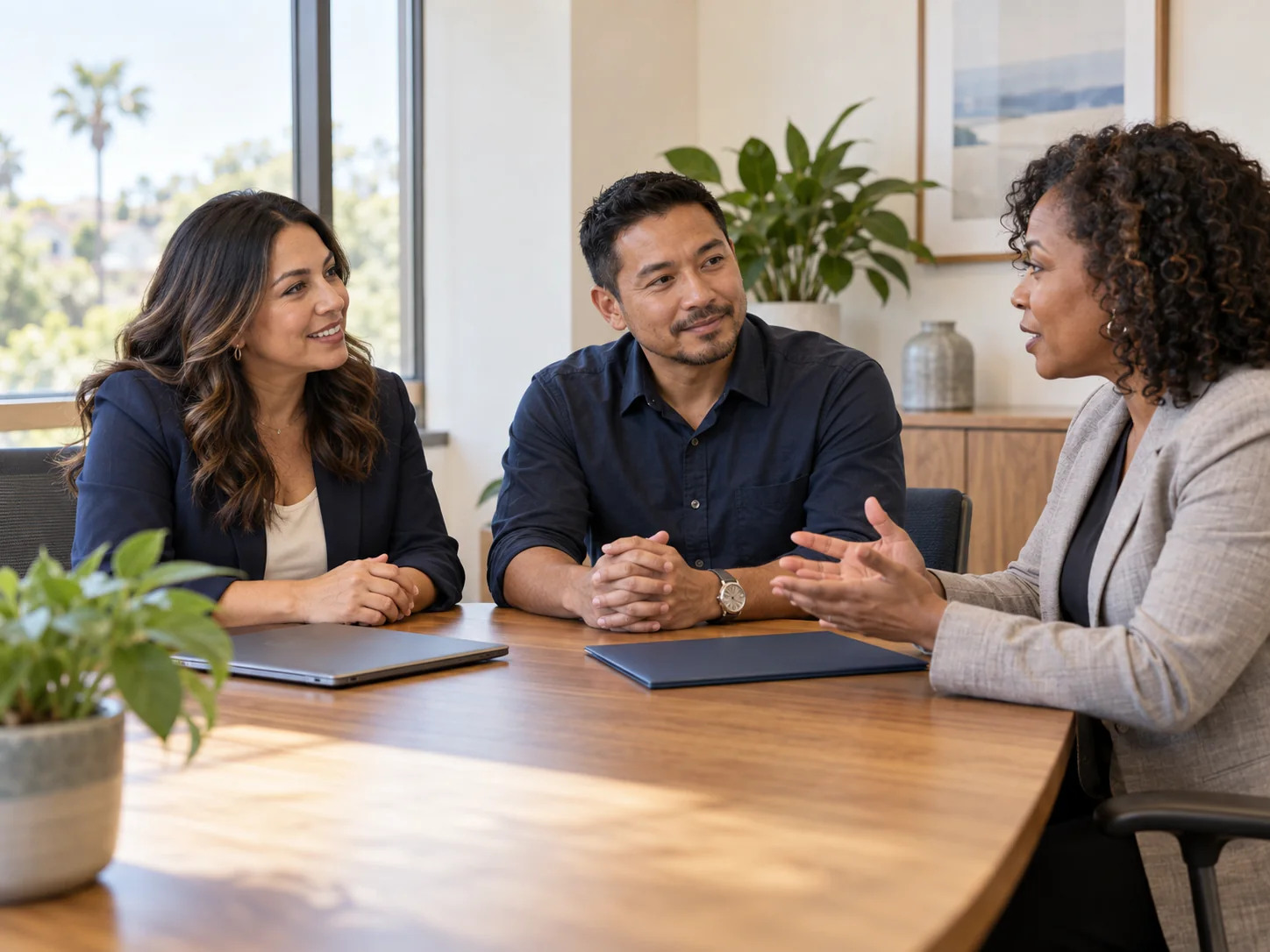Three professionals discussing a member homebuyer program at a table.