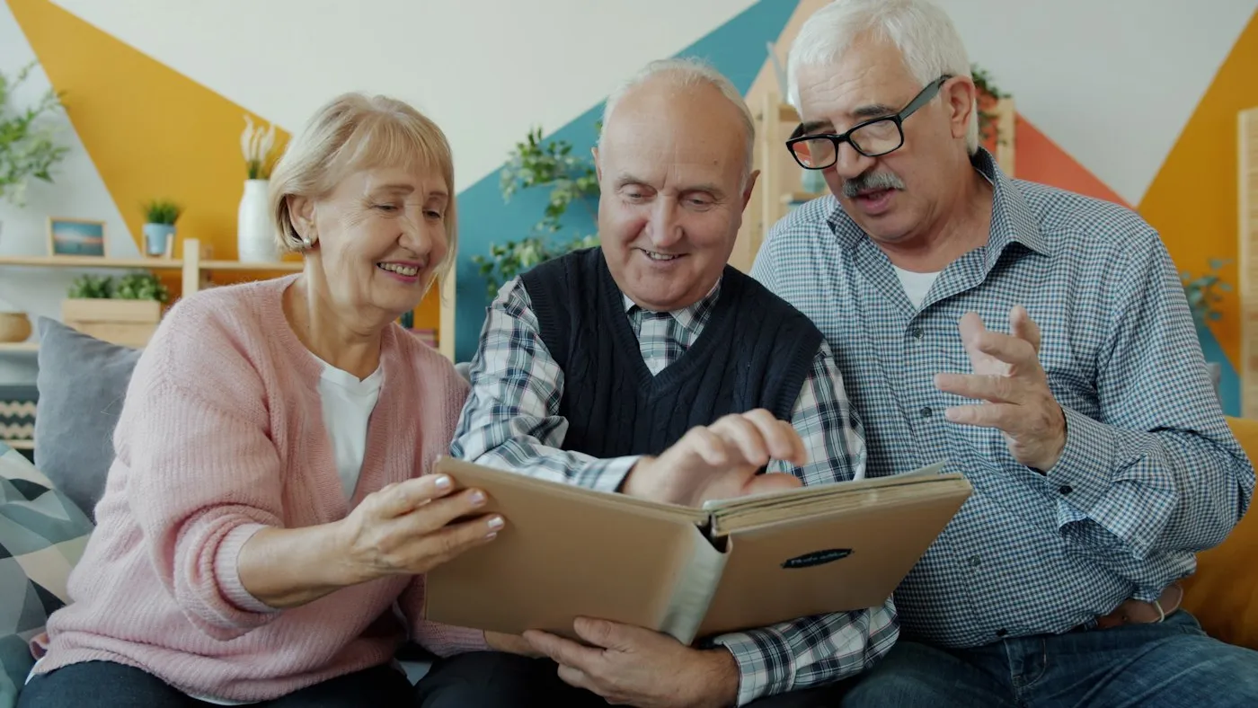 Three seniors looking at a photo album together